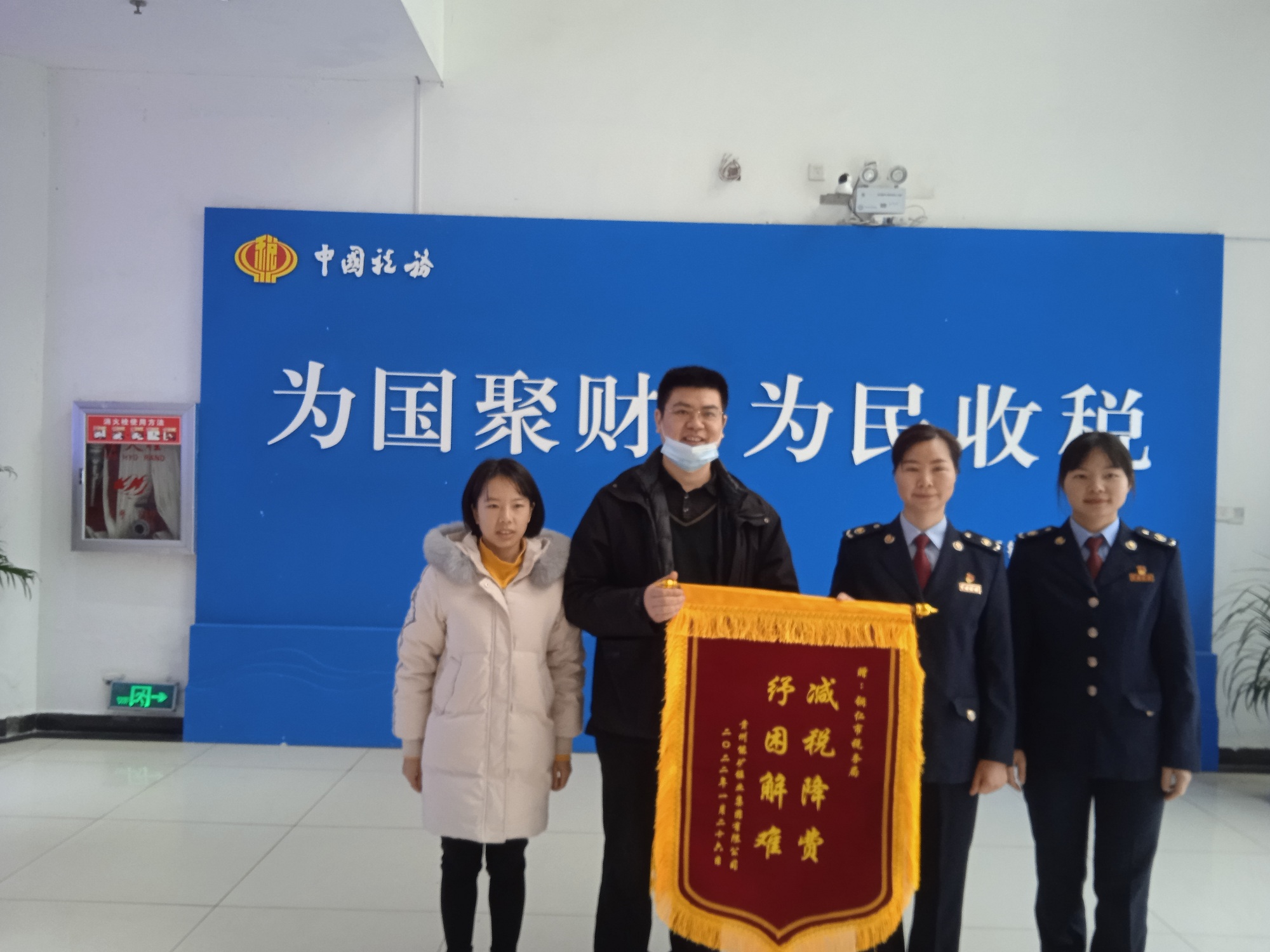 能礦錳業(yè)黨委委員、財務(wù)總監(jiān)張華超代表公司向銅仁市稅務(wù)機關(guān)贈送錦旗.jpg